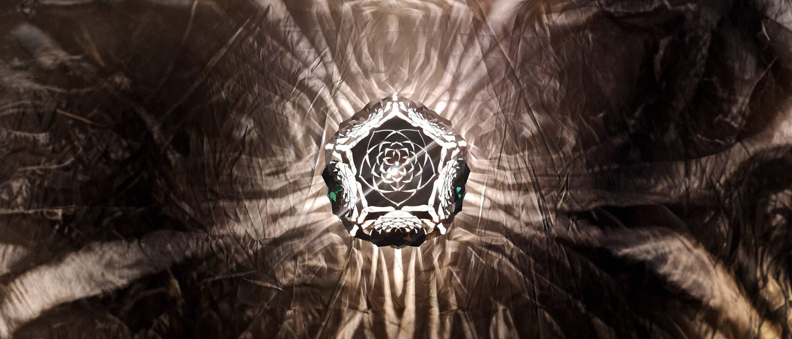 Dodekaeder Platonischer Körper Skulptur: Der Mond (Draufsicht)
Draufsicht von KAGEs beleuchtetem "Der Mond", der in einem dunklen Ambiente komplexe mondlichtartige Muster wirft.