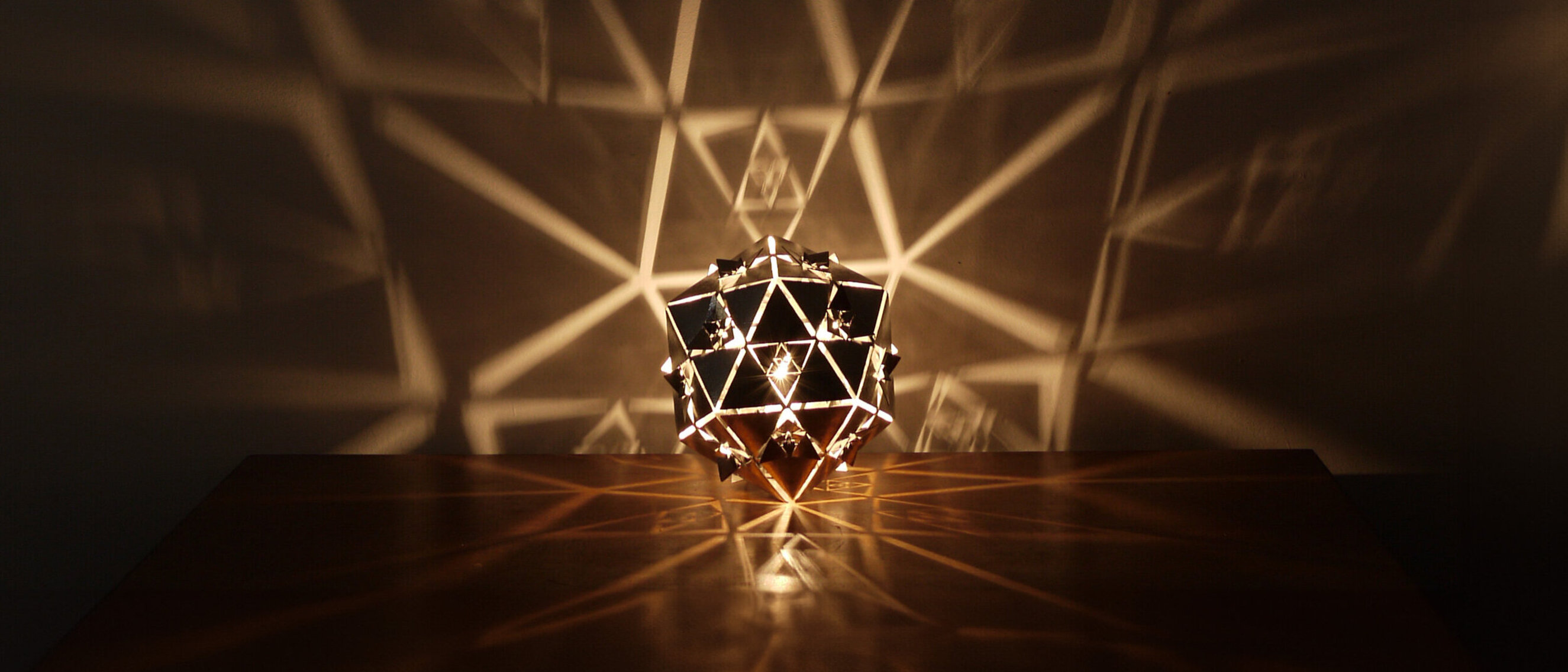 Icosahedron Platonic Solid Lamp: Water (Rotated View)
Diagonal perspective of KAGE's high-gloss polished stainless steel Icosahedron Platonic Solid Lamp, emphasizing the fluid essence of the Water element.