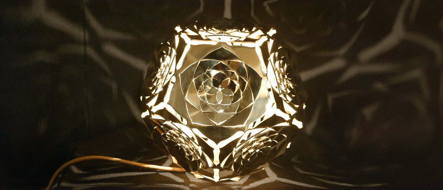 Dodekaeder Platonischer Körper Skulptur: Die Sonne Frontansicht von KAGEs glänzender Messing-Dodekaeder Platonischer Körper Skulptur "Die Sonne", die durch sonnenstrahlen-inspirierte heilige Geometrie das Wesen des Äthers einfängt.