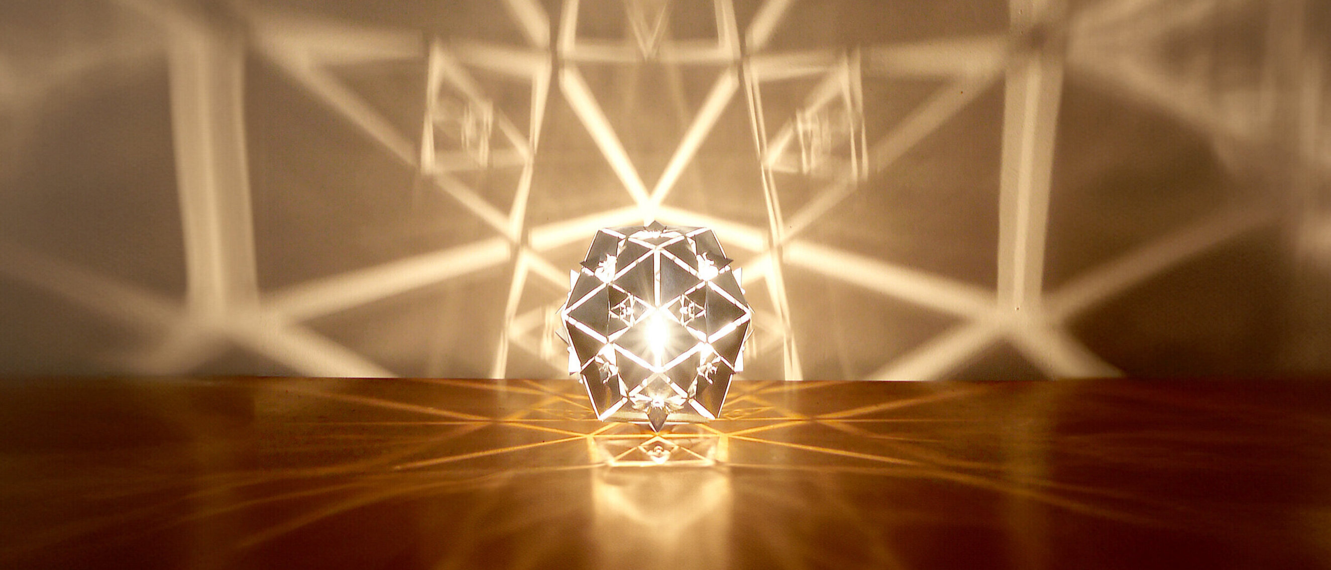 Icosahedron Platonic Solid Lamp: Water
Front view of KAGE's radiant high-gloss polished stainless steel Icosahedron Platonic Solid Lamp representing the Water element.