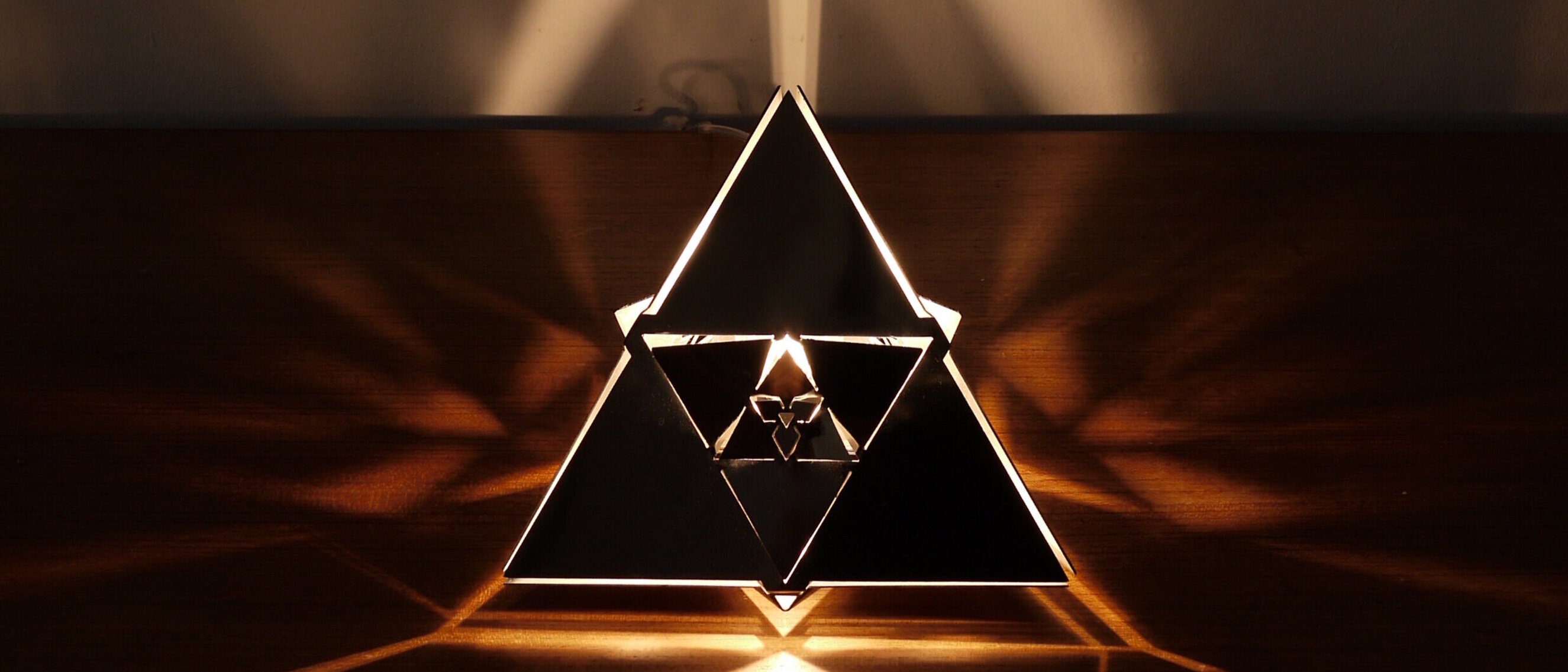 Tetrahedron Platonic Solid Lamp: Fire (Close Up)
Detailed perspective of KAGE's Tetrahedron Platonic Solid Lamp, highlighting the shimmering high-gloss polished stainless steel and intricate fractal patterns of the Fire element.