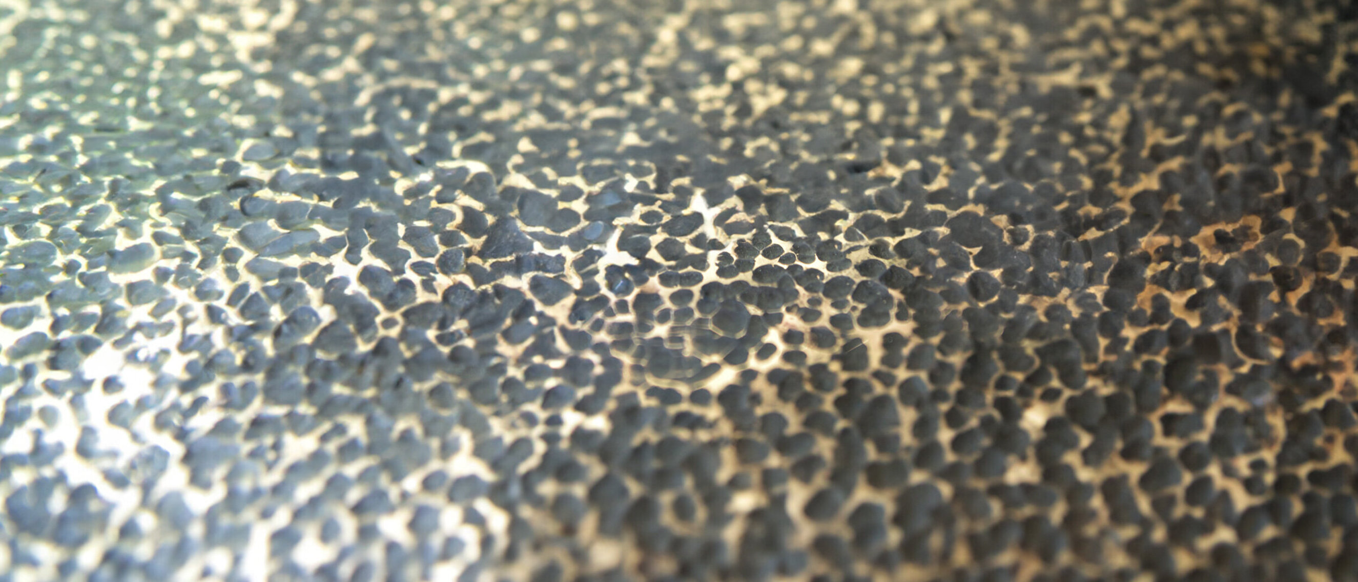 High Gloss Blackened Hammered Brass Close-up of a high gloss blackened and hammered brass surface.