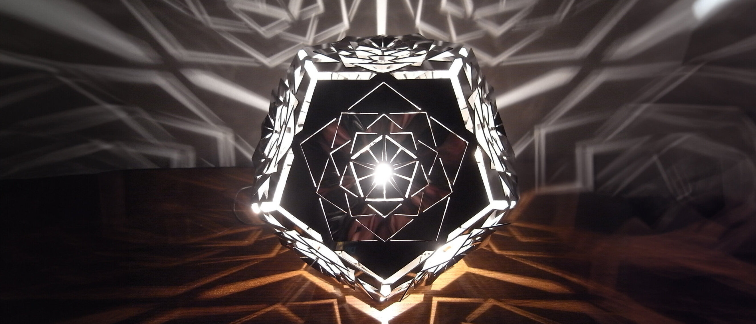 Dodecahedron Platonic Solid Lamp: Ether (Rotated View)
Rotated view of KAGE's Dodecahedron Platonic Solid Lamp in gleaming high-gloss polished stainless steel, reflecting the Ether element's grandeur.