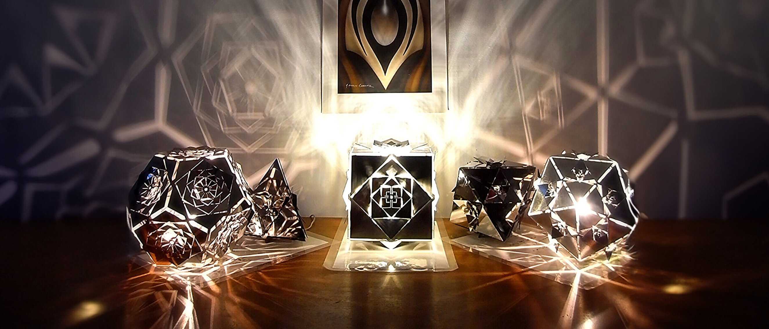 Platonic Solids Collection by KAGE: Lamps Illuminating the Darkness
KAGE's collection of five lamps, brilliantly illuminated, casting intricate patterns of light and shadow in the darkness.